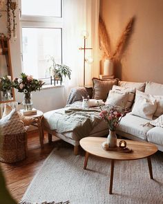 a living room filled with lots of furniture and flowers on top of a coffee table