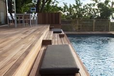 a wooden deck next to a swimming pool