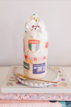 a jar filled with whipped cream and sprinkles on top of a plate