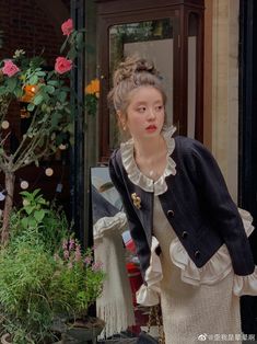 a woman standing in front of a flower shop