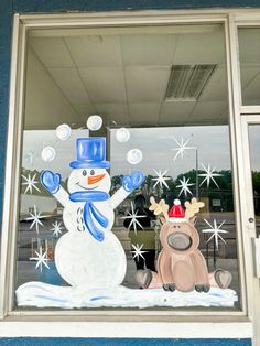 a snowman and reindeer are in the window