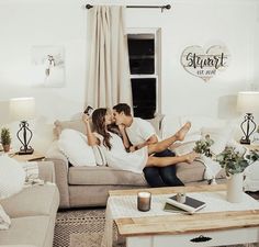 a man and woman sitting on a couch in a living room next to each other