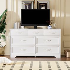 a white dresser with a flat screen tv on top of it in a living room