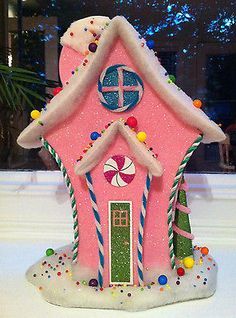 a pink house on the ice rink with trees and lights in the window behind it