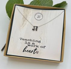 a necklace with the words teaching is a work of heart on it in a box