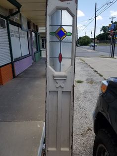 an old door with stained glass on the side of it in front of a building