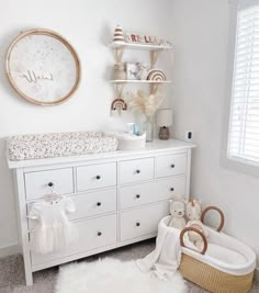 a baby's nursery room with white furniture and decor on the walls, including a crib