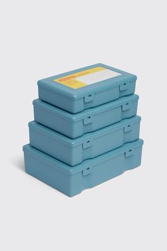 four blue storage boxes stacked on top of each other with a yellow label in the middle