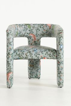 an upholstered chair with flowers and birds painted on the back, sitting in front of a white background