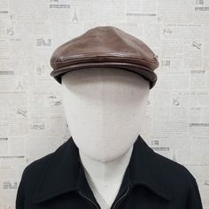 - Classic ivy flat ascot cap style to provide sleek and refined look - Made with vintage leather to give worn, broken in taste - Available in black and brown - Available in S/M (56-57cm) or L/XL (58-61cm) with an elastic sweatband to provide a comfortable fit - Hand-sewn exquite metal Emstate trim - Sewn Visor - Please note wrinkles and variations in color within the cap are part of the intended design and look and is not a defect - All Emstate products are proudly manufactured in USA. - Please Retro Brown Beret For Fall, Brown Retro Beret For Fall, Vintage Flat Cap Beret For Fall, Vintage Beret For Fall, Classic Brown Flat Cap, Classic Leather Hat With Flat Bill, Vintage Brown Leather Hat, Vintage Brown Beret For Winter, Classic Leather Flat Bill Hat