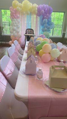 a table set up with balloons and other decorations for a birthday party or baby shower