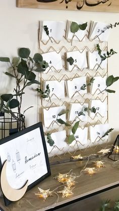 a table topped with lots of plants next to a wall mounted calendar on the wall