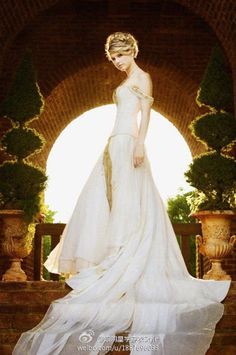 a woman in a white dress standing on some steps