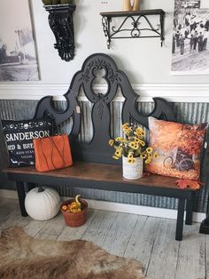 a bench that has some flowers on it and two pumpkins in front of it