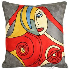 a red and yellow pillow with a woman's face painted on the front side