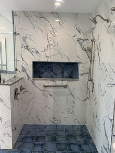 a bathroom with marble walls and blue tile