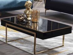 a black coffee table with gold accents and a glass top on a rug in a living room