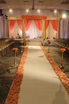 the aisle is decorated with red and orange flowers