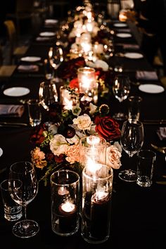 Low centerpieces with burgundy, blush and ivory flowers for a dark romantic wedding with a moody tone using black linens Dark Reception Wedding Ideas, Dark Romantic Table Setting, Dark Wedding Place Settings, Dark Candle Wedding, Red And Black Romantic Wedding, Moody Romantic Wedding Vibe, Romantic Dinner Table Set Up For 2, Dark Wedding Venue Aesthetic, Dark Romantic Centerpiece