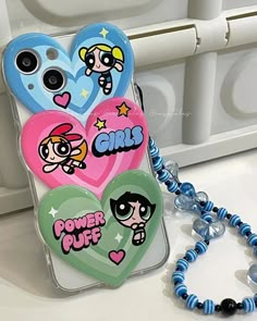 a cell phone case with cartoon characters on it and a beaded bracelet attached to the back