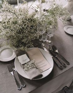 the table is set with silverware and place settings