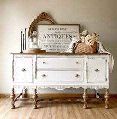 a white dresser with an antique sign above it