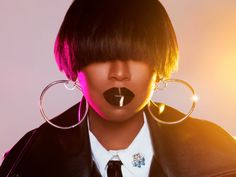 a woman with black lipstick and large hoop earrings