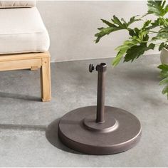 an umbrella stand on the ground next to a potted plant