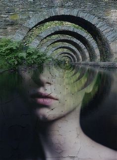 a woman's face is reflected in the water with trees growing out of it