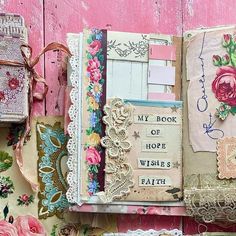 an altered book with flowers and laces on the pages is displayed against a pink painted wall