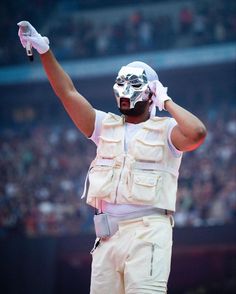 a man in white is holding his hands up to the side while wearing a mask