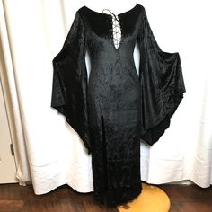 New Old Stock New In Package Discontinued - Retired Long Sexy Stretch Velvet - Plunging Neckline Large Batwing Sleeves Slit Over Right Leg Long Zipper In Back Great For Any Dark Character Elvira Goth Witch Dark Angel Vampira Dress Is On A Mannequin That Measures B37-W-27-H36 There Is Good Stretch To The Dress Wings Are Not Included Tag Med/Lrg Approx Flat Lay Pit To Pit 18” Waist 16” Hip 18” Side Seam Pit To Hem 47” Ctr Back Neck To Hem 51” Front Slit 27” Tag Sml/Med Approx Flat Lay Pit To Pit 1 Witchy Dresses, Black Dress Gothic, Dark Character, Long Mermaid Dress, Gothic Bag, Belle Costume, Goth Witch, Plus Size Halloween Costume, Witch Dress