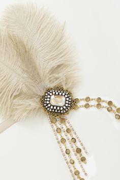 Step back in time to the Jazz Age with this feather headband, a modern nostalgia for the glamorous 1920s Features: Elegant tinted feather and high-quality beads Beaded floral pendant design Adjustable ribbon band Dangling beaded chains Note: This Creamy Beige headband is limited to GROUND SHIPPING ONLY. If expedited shipping is selected at checkout, all other items will be shipped via expedited shipping, while this item will be shipped separately by ground shipping. 1920s Hair Accessories, Beige Headband, Modern Nostalgia, 1920s Accessories, Flapper Headpiece, 1920s Headpiece, 1920s Hair, The Jazz Age, Vintage Headpiece