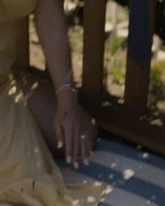 a woman sitting on a porch with her hand in the air