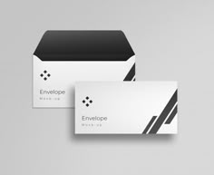 two business cards with black and white stripes on them, one has an envelope in the middle