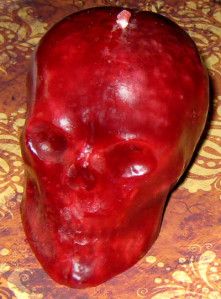 a red apple with a skull on it's side sitting on top of a table