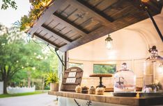 an outdoor food cart with lots of items on the counter and hanging from it's roof