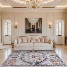 a living room with a couch, rug and chandelier