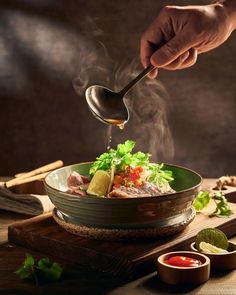 a person is spooning food out of a bowl with chopsticks in it