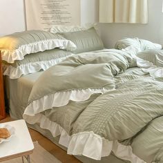 an unmade bed with ruffled sheets and pillows on top of it in a bedroom