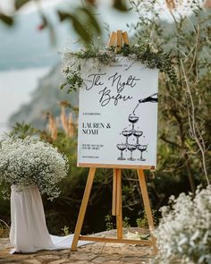 an easel with flowers on it next to a sign