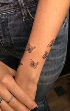 a woman's arm with butterflies on it and the wrist is shown in black ink