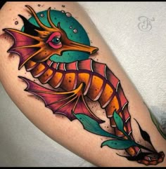 a colorful seahorse tattoo on the thigh