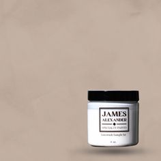 a jar of jam sitting on top of a white table next to a brown wall