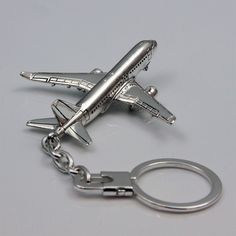 a silver metal keychain with an airplane on it's front and back ends