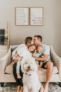 a family sitting on a couch with their dog