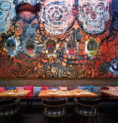 a large mural in the middle of a restaurant with skulls on it's wall