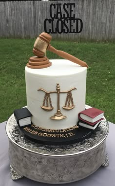 a cake that is sitting on top of a silver platter with a judge's gaven and books