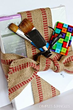 a gift wrapped in burlap and tied with a bow, includes a brush