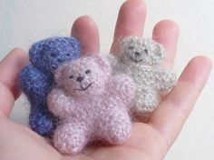 three small crocheted teddy bears sitting in someone's hand